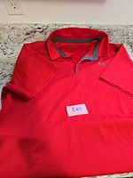 Front view of red Under Armour polo showing logo and collar