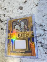Front of Panini Gold Gear Cam Akers jersey card showing player image, gold design, and jersey swatch