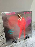 Front cover of Nolan Struck Hard Working Man LP in shrink wrap on stand