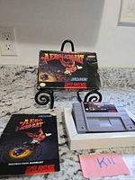 Front view of box on stand with cartridge, manual, insert visible