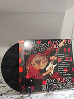 Front view of vinyl partially out of sleeve displaying cover art