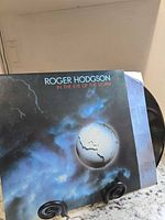 Front view of LP jacket on stand with record partly exposed