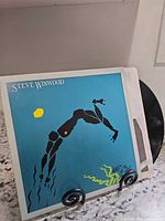 Front cover of Steve Winwood Arc of a Diver vinyl with record partly visible