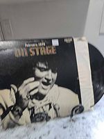 Front of Elvis Presley "On Stage" LP sleeve showing title and performer, vinyl partially visible