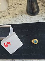 Top view of ring showing blue center stone and rhinestone halo