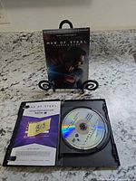 Slipcover standing behind open case showing one disc and insert