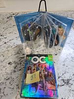 Front view showing holographic slipcase and disc holder fanned open displaying picture-printed DVDs