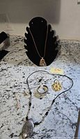 Full lot overview showing both necklaces on display stand and countertop plus rings, pendant, bracelet