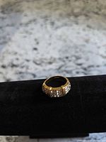 Full view of ring on display showing design and stones