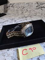 Side view of watch on display tray showing bracelet and crystal bezel