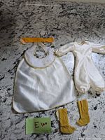 All clothing pieces laid out: jumpsuit, robe, sash, boots