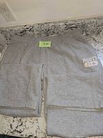 Front view of grey Roots sweatpants showing overall appearance and logo