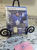 Front view of sealed PS5 NHL 22 game case on stand