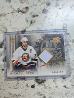 Front of Michael Peca jersey card with serial number and swatch