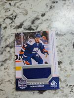 Front of Thomas Hickey jersey card showing player image and blue jersey swatch