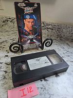 Front of Street Fighter VHS sleeve on stand with tape in foreground