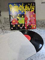 Front cover of Rockpile Seconds of Pleasure album with vinyl disc partially removed from inner sleeve