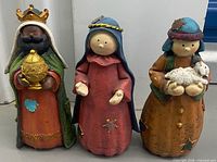 Front view of all three figurines showing design and wear