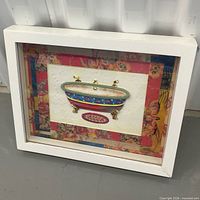 Front view of framed bathtub print showing image, matting, and frame