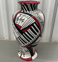 Full view of tall ceramic vase with musical design