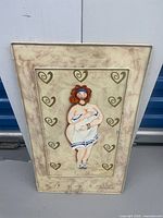 Front of painted metal mirror cover showing figure and hooks