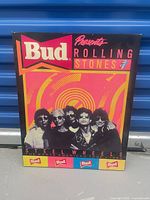 Front view of mounted poster showing Budweiser logo, Rolling Stones text, band image and colours