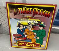 Front view of colorful Three Stooges metal sign