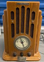 Front view showing wood cabinet, speaker grille, tuning dial, control knobs, limited edition plaque