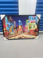 Front view of framed Times Square photo print with cardboard corner protectors