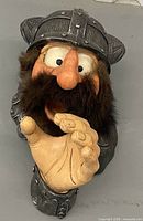 Front view of Viking head wall statue showing helmet, beard and extended hand