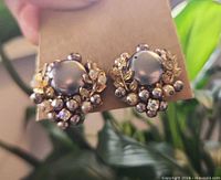 front view of both earrings showing cabochon centers and surrounding pearl clusters