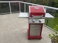 Front view of red Nexgrill Deluxe gas grill on patio