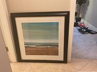 Full view of framed beach print leaning against wall