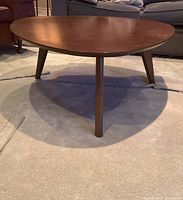 Front angle of coffee table showing shape, finish and leg style