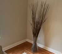 Full view of vase with branches in corner