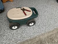 Rolling garden stool closed with clippers on lid