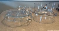 Group shot of all glass pieces: platter, dip bowl, dome, vases, salad bowls
