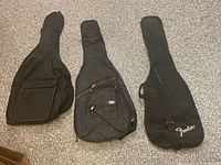 Front view of three black guitar gig bags