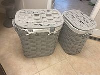 Front view of both hampers showing woven exterior and lids
