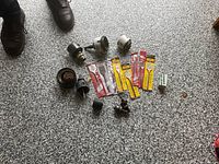 Group view of hole saws, mandrels, and packaged spade bits on floor