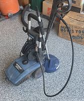 Front and side view of pressure washer with hose and surface-cleaner attachment attached