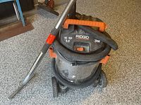 Full view of RIDGID wet/dry vacuum with hose and wand attached