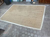 Full view of seagrass rug lying flat on brick floor