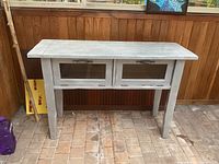 Front view of silver-gray wooden side table with two glass-front drawers closed