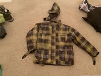 Front view of plaid ski/snowboard jacket showing pockets, hood and overall condition