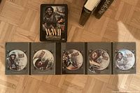 Open metal case showing five WWII Battlefront DVDs; partial view of hardcover books