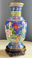 front view of cloisonné vase on wooden stand