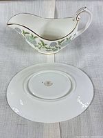 Gravy boat side view with floral pattern and gold trim