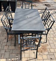 Full view of table with six chairs arranged around it