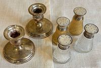 Two sterling candlesticks, four shakers grouped